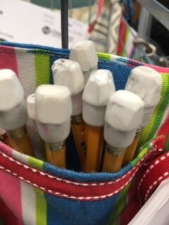 Pencils with white cap erasers in a colorful pocket.